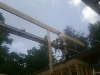 Carpenter setting a ridge beam over a new addition frame — Ice Dam Removal by Roofing Brothers in Pinole