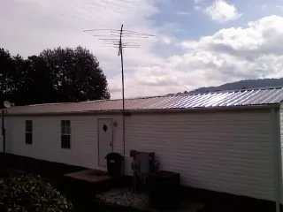 New metal roof on a single wide mobile home with a TV antenna in Pinole