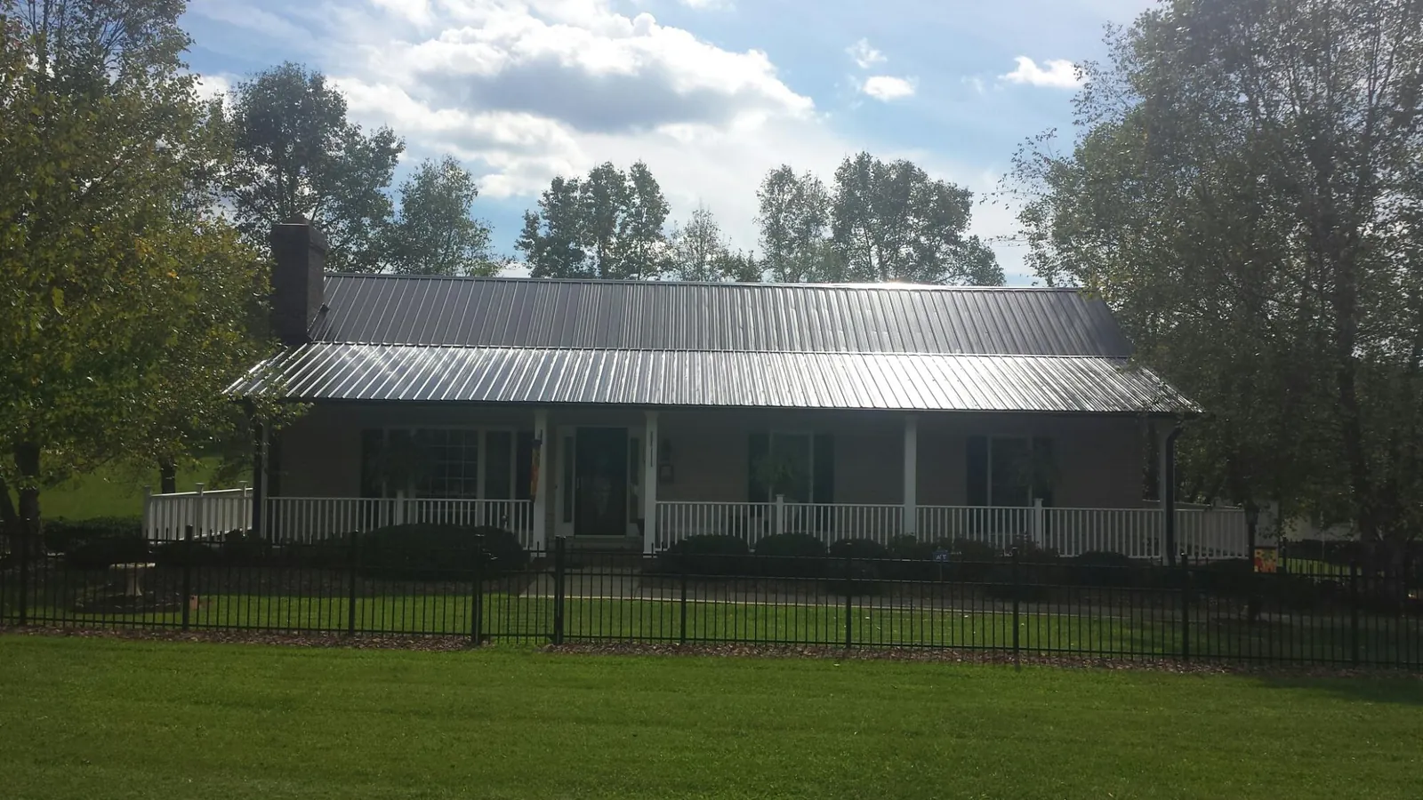 Gray metal roof on a brick ranch with a full width front porch — Gutter Guard Installation work by our crew in Pinole